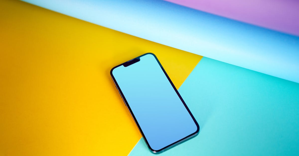 Modern smartphone lies on a vivid, colorful background, emphasizing technology and design.