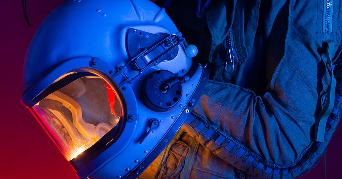 A person in a spacesuit holding an astronaut helmet with colorful lighting.